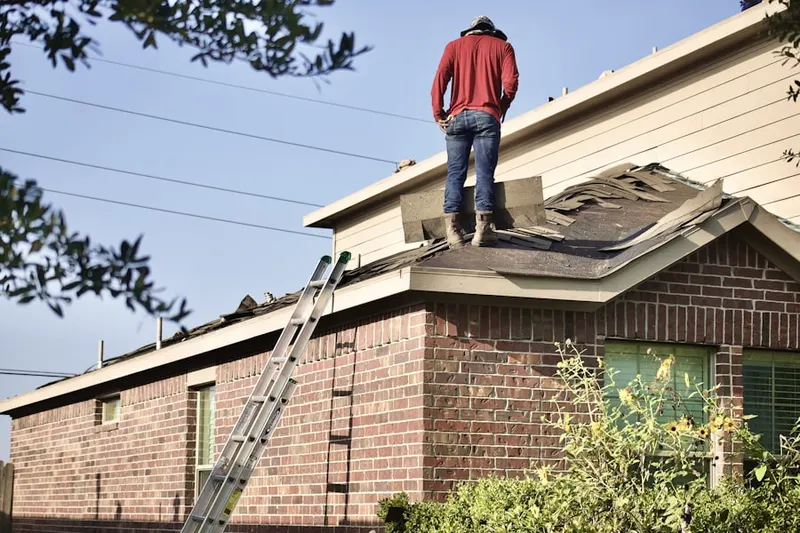 Professional roofer working on a residential roof in Fort Polk South